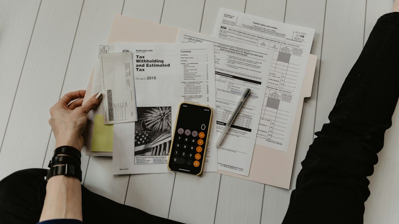 Calculator, pen and financial paperwork on a desk